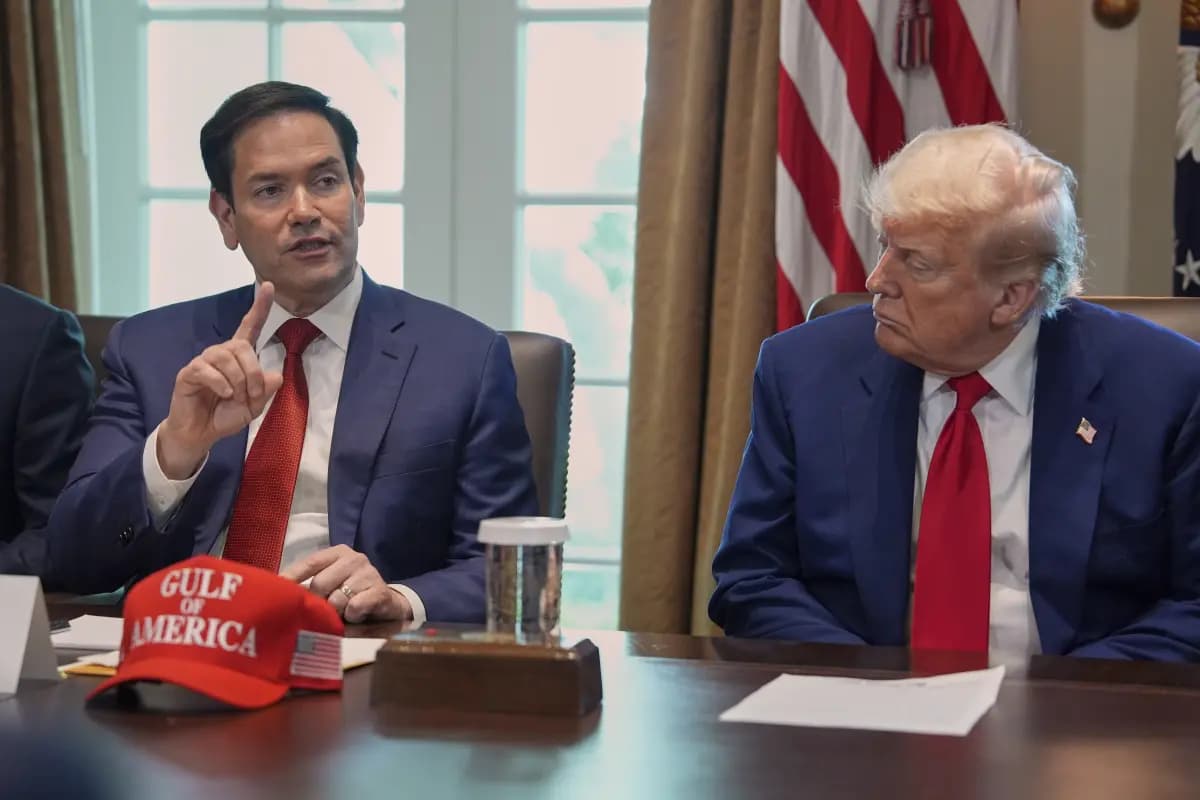 U.S. politician Marco Rubio appearing solemn as he adjusts his tie and looks downward in front of a backdrop reading "Can..."